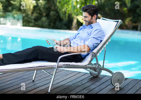 Kluger Mann mit digital-Tablette in der Nähe von Schwimmbad Stockfoto