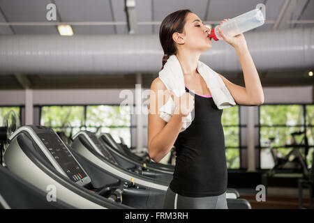 Frau am Laufband Trinkwasser in Turnhalle Stockfoto