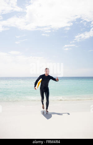 Surfer am Strand mit einem Surfbrett Stockfoto