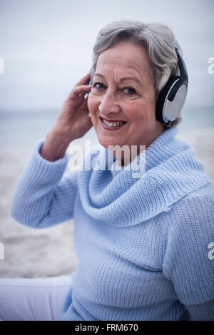 Porträt von senior Frau anhören von Musik über Kopfhörer Stockfoto