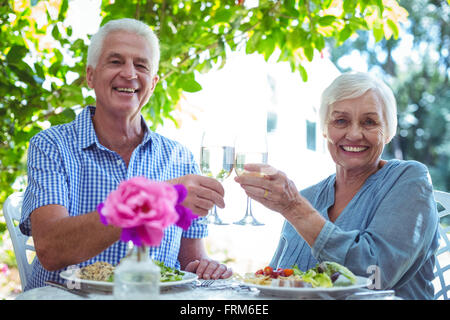 Älteres Paar, toasten Weißwein lächelnd Stockfoto