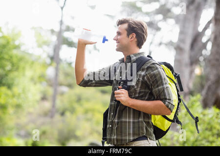 Junge Wanderer Trinkwasser stehen im Wald Stockfoto