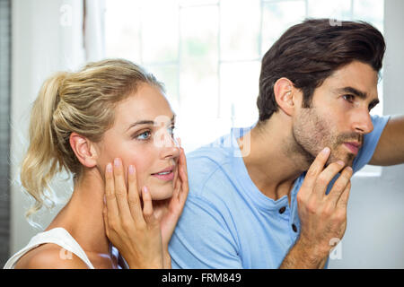 Mann und Frau, die Überprüfung ihrer Haut im Badezimmer Stockfoto