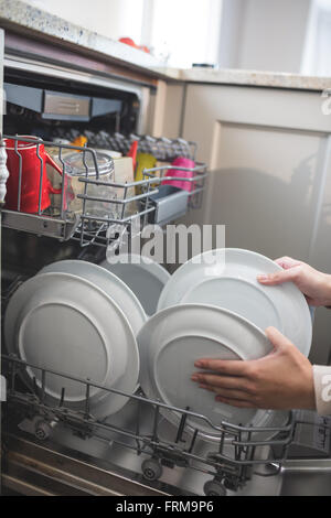 Frau, die Vermittlung von Platten in Spülmaschine Stockfoto