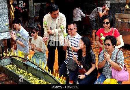 Chiang Mai, Thailand: Gläubige Thais halten Lotusblumen beten vor eine Kerze Laube am Wat Doi Suthep Stockfoto