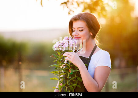 Junge Gärtner in ihrem Garten, Blumen, sonnige Natur riechen Stockfoto