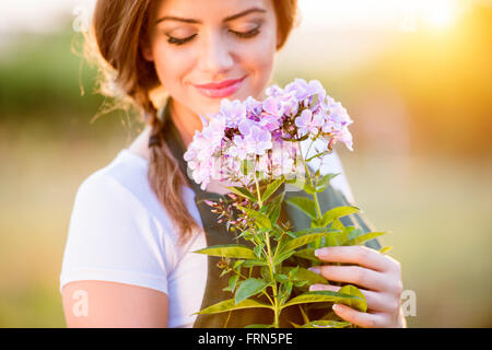 Junge Gärtner in ihrem Garten mit Blumen, sonniges Gemüt Stockfoto