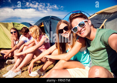 Jugendliche sitzen auf dem Boden vor Zelten Stockfoto