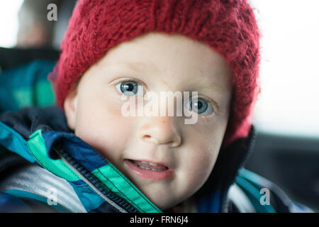 Porträt eines 3 Jahre alten Jungen im Winter in die Kamera schaut Stockfoto