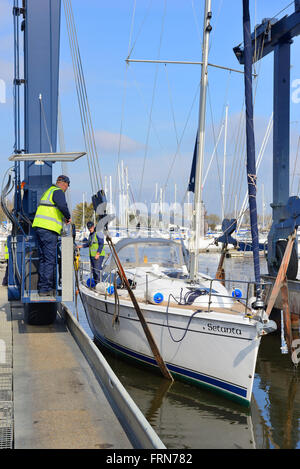 Yacht wird nach Winterlagerung wieder ins Wasser gehisst auf dem harten Stand in Premier Chichester Marina - Chichester, West Sussex, UK Stockfoto