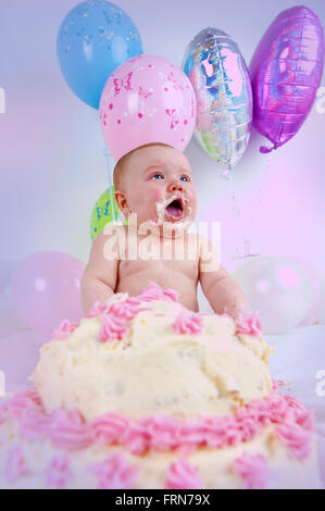 Ein Baby Zerschlagung einer Geburtstagstorte Stockfoto
