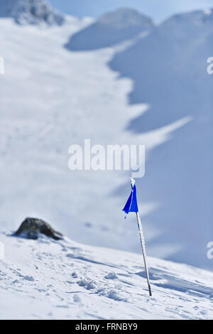 Blaue Flagge durchgebrannt durch den Wind auf einem Berg im winter Stockfoto