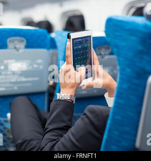 Geschäftsmann mit Tablet Telefon auf Flugzeug. Stockfoto