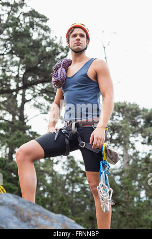 Niedrigen Winkel Sicht des Menschen, die auf Felsen im Wald Stockfoto