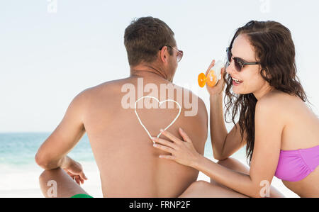 Auftragen von Sonnencreme auf Freund Freundin Stockfoto