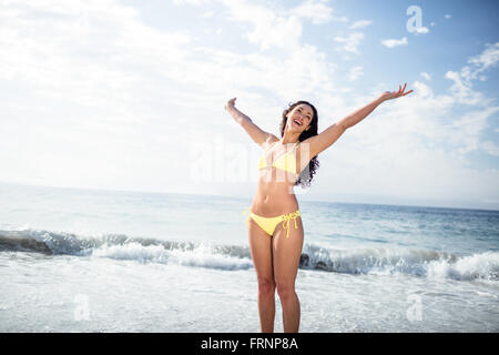 Unbeschwerte Frau im Bikini stehen am Strand Stockfoto