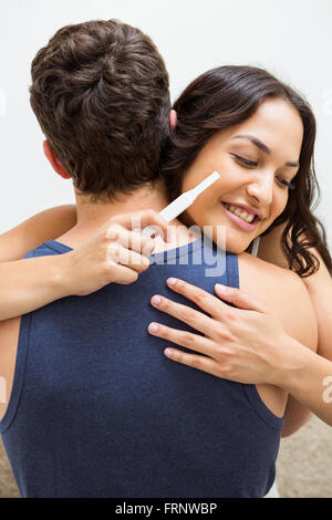 Frau betrachten Schwangerschaftstest und genießen Sie einen Mann Stockfoto