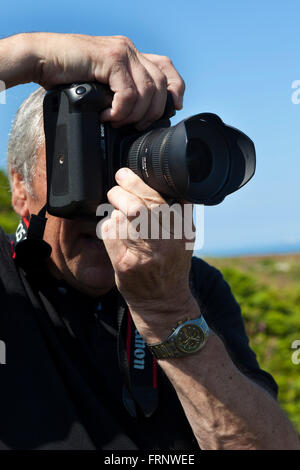 Toursits und Besucher auf der Insel Skomer vor der Küste von Pembrokshire in Wales mit ihren Kameras, um die Papageientaucher zu fotografieren, die reichlich auf der Insel sind. Stockfoto