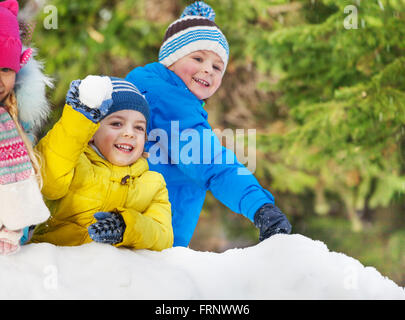 Kleine Jungs werfen Schneebälle im Winter park Stockfoto