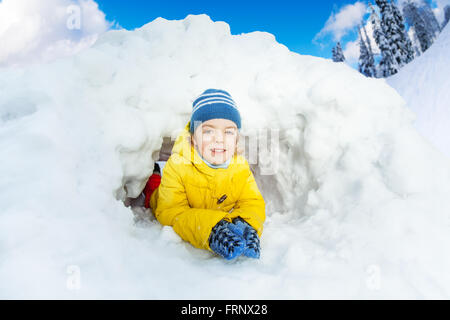 Kleiner Junge in gelb innen Schneehöhle Stockfoto