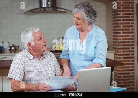 Ehepaar im Ruhestand diskutieren bei der Berechnung der Rechnungen mit laptop Stockfoto