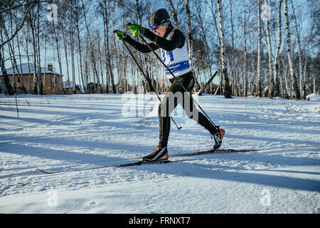 der klassische Stil im Winterwald auf Rennen während der Meisterschaft von Tscheljabinsk im Langlauf in mittleren Alters männlichen Skifahrer Stockfoto