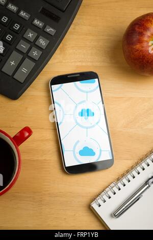Smartphone mit Cloud-computing-Anwendungen auf Schreibtisch Stockfoto