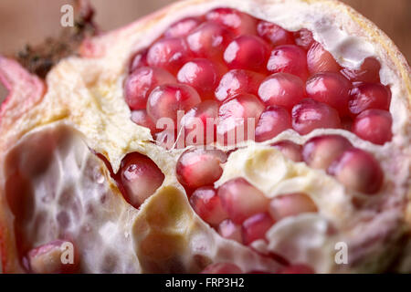 Makro öffnen Granatapfel halbieren auf hölzernen Hintergrund Stockfoto