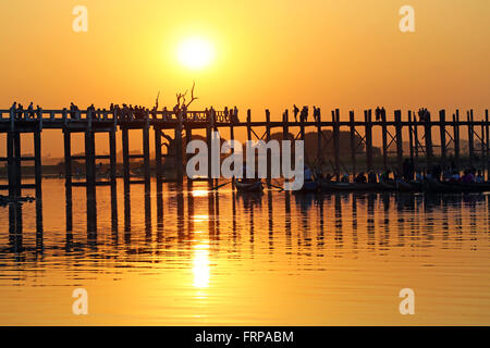 Menschen, die über die U Bein Brücke über den Taungthaman-See bei Sonnenuntergang in Amarapura, Mandalay, Myanmar (Burma) Stockfoto