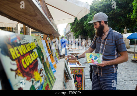 Ein junger Mann schaut Vintage Bücher auf den Straßen in Havanna, Kuba. Stockfoto