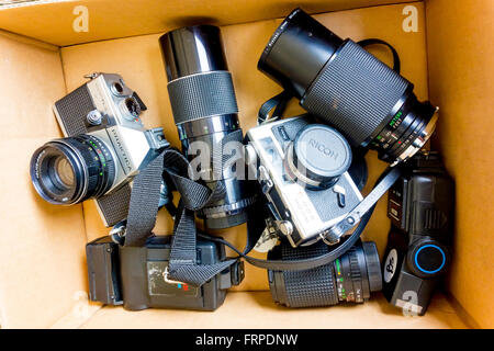 Eine Sammlung von alten 35mm-Film-Kameras, objektive und Blitzgeräte für den Verkauf auf einem Flohmarkt-Stand. Stockfoto