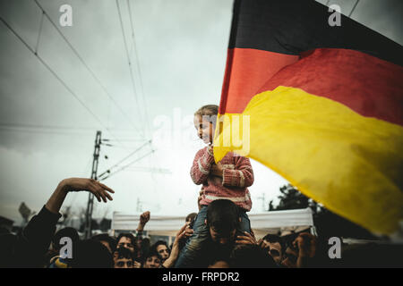 Idomeni Flüchtlingslager auf griechisches Mazedonien Grenze, syrische Flüchtlinge Protest, Pro-Merkel-Rallye, winkt eine Mädchen eine deutsche Flagge, Idomeni Stockfoto