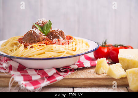 Ein Teller mit Spaghetti mit Fleischbällchen, garniert mit geriebenem Parmesan und Basilikum. Stockfoto