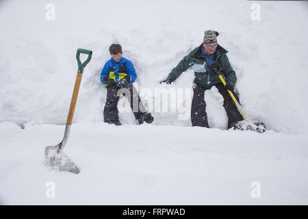 Denver, Colorado, USA. 23. März 2016. JACK FINK, 9, links, und VANESSA FINK eine Pause vom Schaufeln am Mittwoch im Schnee sitzen. Starke Winde und schwere verschneite Großraum Denver im Frühjahr Blizzard heute. Bildnachweis: Matthew Staver/ZUMA Draht/Alamy Live-Nachrichten Stockfoto