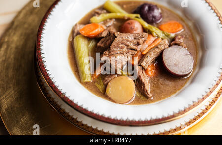 Klobige Rindergulasch in einer gold umrandeten Porzellanschüssel. Stockfoto