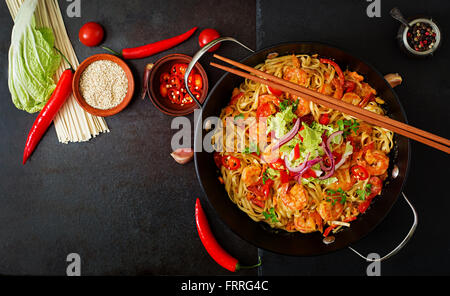 Udon-Nudeln mit Garnelen, Tomaten und Paprika. Ansicht von oben Stockfoto
