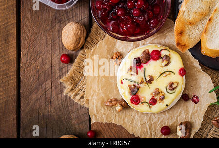 Gebackener Käse Camembert mit Preiselbeeren und Nüssen. Ansicht von oben Stockfoto