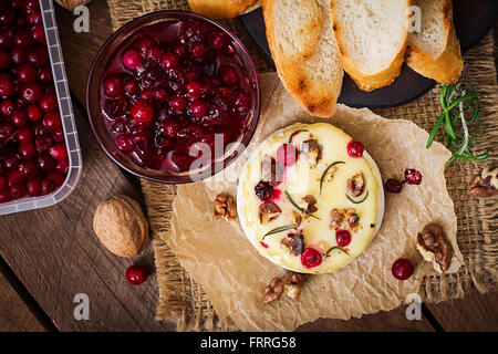 Gebackener Käse Camembert mit Preiselbeeren und Nüssen. Ansicht von oben Stockfoto