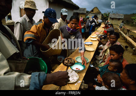 Teilnahme an einer Umbettung Zeremonie in Belaveno, Bezanozano ethnischen Bereich, Madagaskar, serviert Speisen von der Gastfamilie. Stockfoto