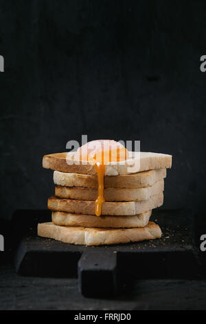 Toast mit Eigelb über schwarz Stockfoto