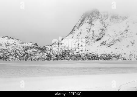 Storvatnet See vor der Landschaft der Lofoten Berge auf der Insel Flakstadoy im Winter. Stockfoto