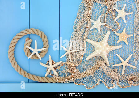 Seestern Muschel abstrakte Collage mit Seil und Fischnetz über hölzerne blauen Hintergrund. Stockfoto