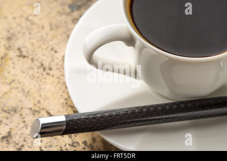 Tasse Kaffee mit Stift auf dem Tisch Stockfoto