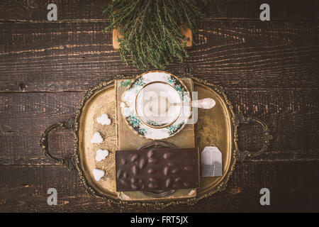 Tee-Set mit Kraut und Schokolade auf dem Holztisch Stockfoto