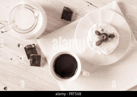 Tasse Kaffee mit Krug Milch Kuchen und Schokolade auf die weiße Tischplatte-Ansicht Stockfoto