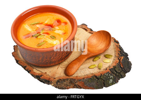 Kleine Keramikschale Kürbis Creme Suppe, Holzlöffel, schneiden Scheibe Brot und Samen auf Holz isolierten auf weißen Hintergrund, hohe Stockfoto