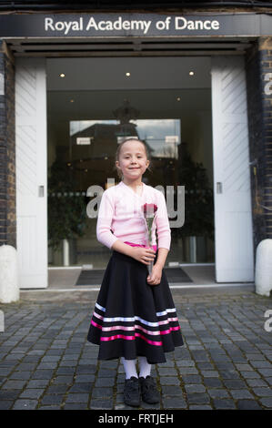 Ein junges Mädchen posiert mit einer roten Rose nach ihrem Grad 1 Ballett Prüfung außerhalb der Royal Academy of Dance in London Stockfoto