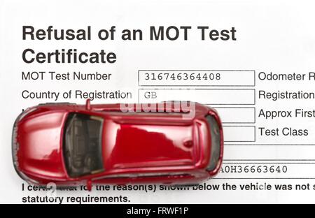 Verweigerung der ein TÜV Zertifikat Testdokument und eine rote Miniatur-Auto. Stockfoto