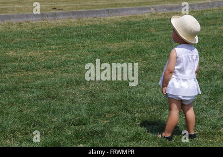 Kleines Mädchen in eleganten weißen Sommer Kleid wegschauen Stockfoto