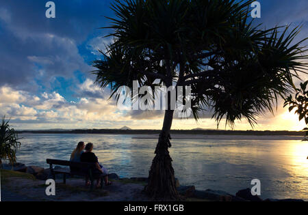 Noosa Beach Szene Australien paar auf Bank bei Sonnenuntergang Stockfoto